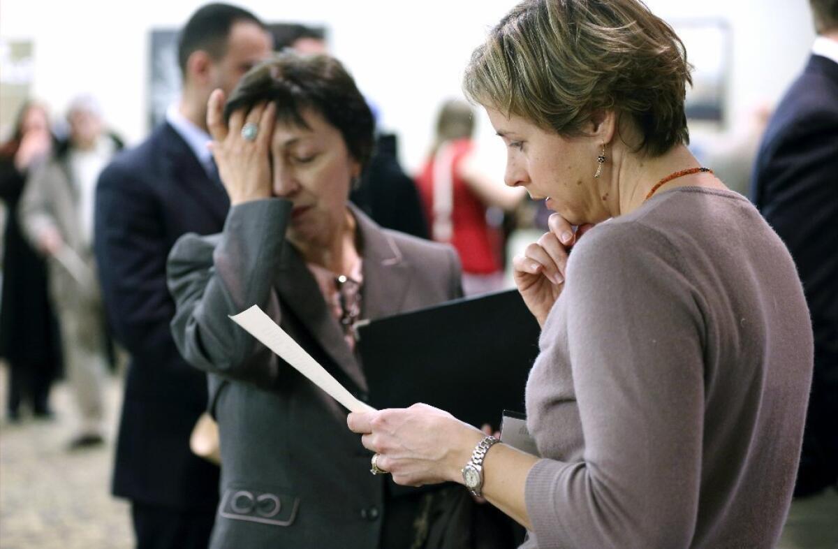 Ann Oganesian, left, of Newton, Mass., pauses as she speaks with a State Department employee about job opportunities with the federal government during a job fair in Boston.