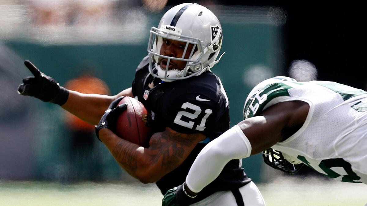 Raiders running back Maurice Jones-Drew, left, tries to avoid being tackled by New York Jets linebacker Demario Davis during the first quarter of Oakland's loss Sunday.