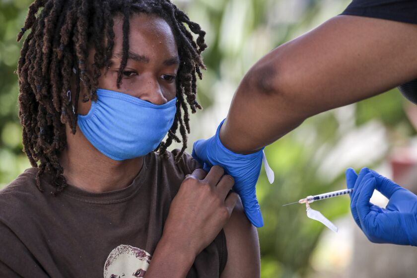 Los Angeles, CA - July 16: Jacob Alexander, 14, gets second dose of Pfizer-BioNTech vaccine at a mobile COVID-19 vaccine clinic, hosted by Mothers In Action in collaboration with L.A. County Department of Public Health at Mothers in Action on Friday, July 16, 2021 in Los Angeles, CA. (Irfan Khan / Los Angeles Times)