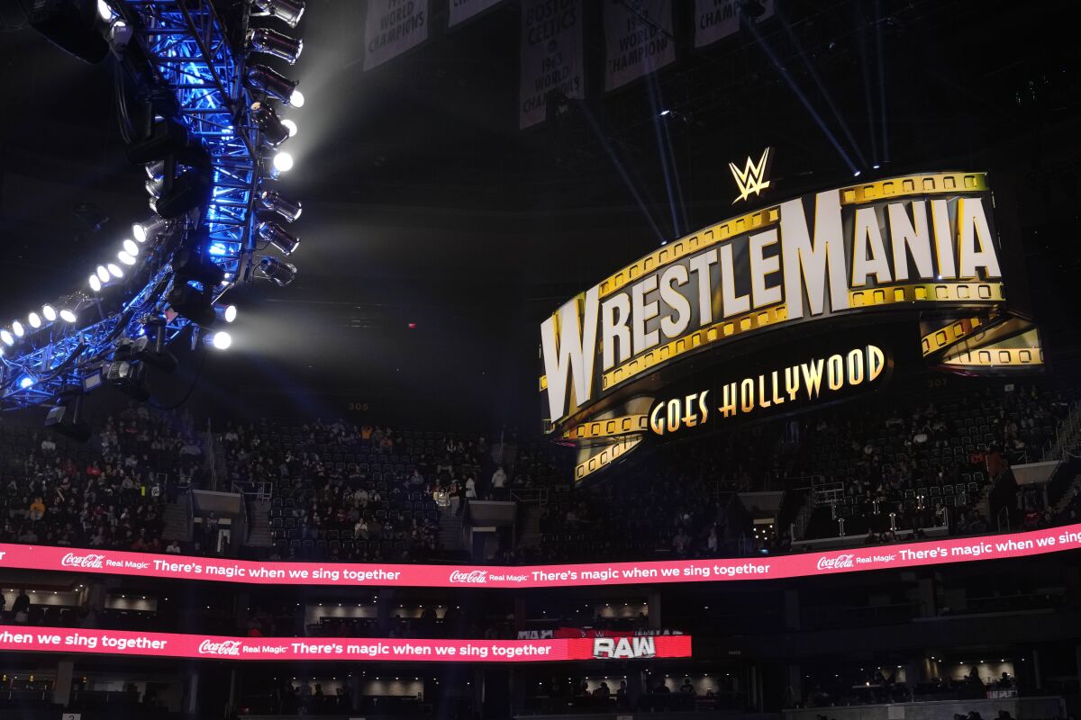 A WrestleMania sign hangs over the crowd during the WWE Monday Night RAW event, Monday, March 6, 2023, in Boston. WWE’s WrestleMania arrives this weekend, Saturday, April 1, to a massive audience and vastly larger advertising revenue as it seeks to establish itself as a serious contender for major advertising bucks. (AP Photo/Charles Krupa)