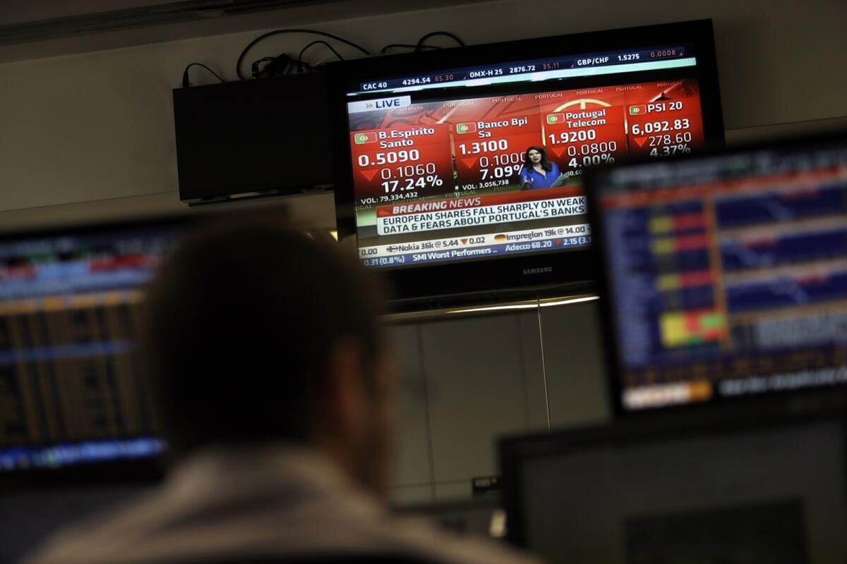 A broker watches a screen displaying financial information about turmoil in the Portuguese stock market and the sharp fall in Portuguese bank Banco Espirito Santo shares, in a trading room of a Portuguese bank in Lisbon Thursday.