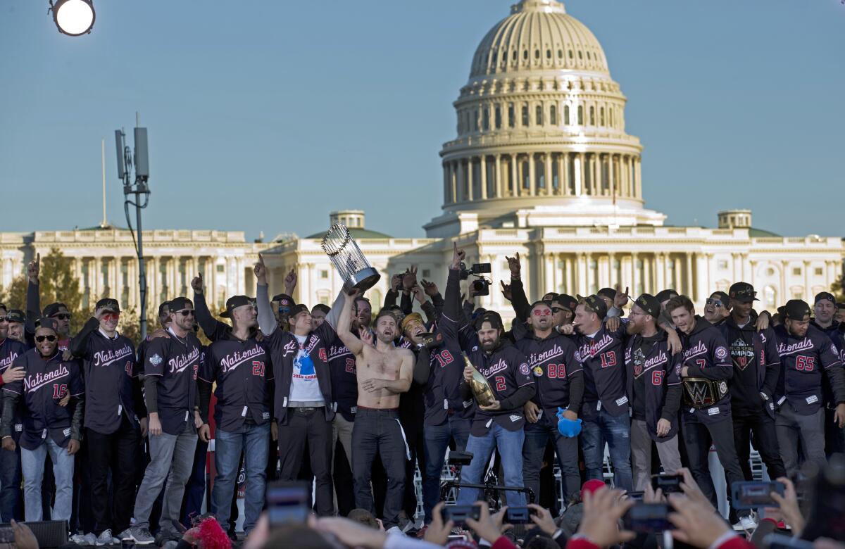 Washington Nationals players raise the World Series trophy during a rally following a  parade on Saturday in Washington D.C.
