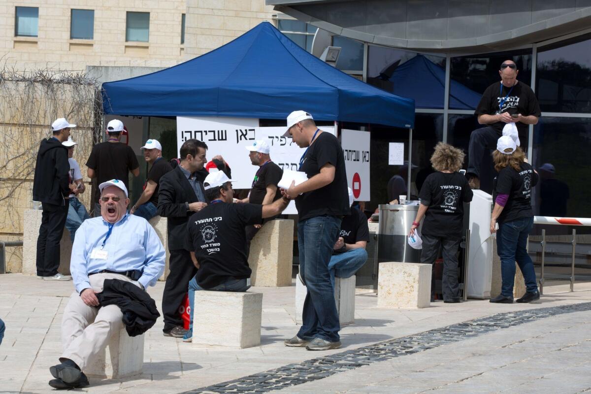 Israeli Foreign Ministry employees gather outside their offices in Jerusalem as they intensified a long-running dispute over pay, declaring a strike at home and at diplomatic missions around the world.
