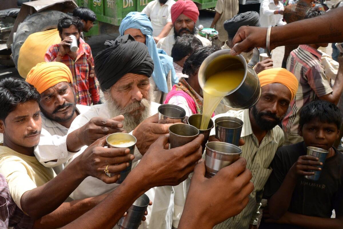 A volunteer pours juice for passers-by in Amritsar, a city in northwestern India, on May 29.