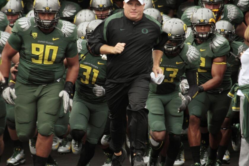 Former coach Chip Kelly and the Oregon Ducks, shown in 2011, received minor penalties from the NCAA on Wednesday for recruiting violations.