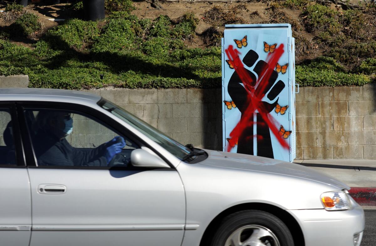 A large red X is painted over an illustration of an upraised fist surrounded by butterflies.