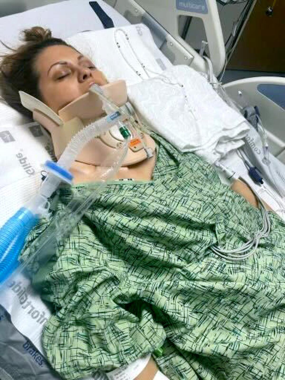 An intubated woman comatose on a hospital bed