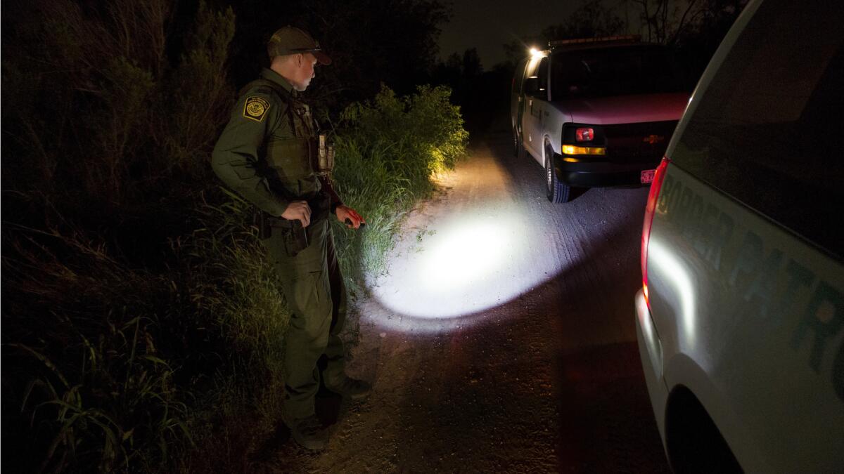 Border Patrol Agent Richard Schweitzer keeps an eye on migrants who had just illegally crossed the Rio Grande in Fronton, Texas.