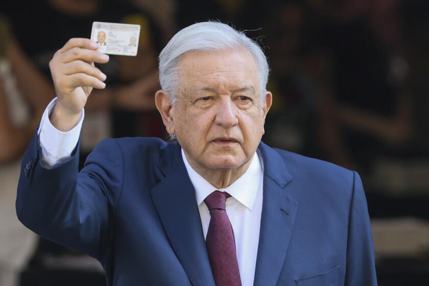 El presidente saliente Andrés Manuel López Obrador muestra su documento de identidad después de votar en las elecciones generales en Ciudad de México, el domingo 2 de junio de 2024. (AP Foto/Ginnette Riquelme)