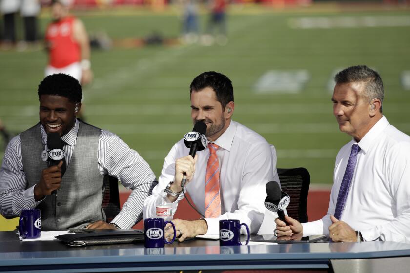 Former Southern California players Reggie Bush, left, and Matt Leinart and former Ohio State coach Urban Meyer rehearse for a pregame show, at an NCAA college football game between Southern California and Utah on Friday, Sept. 20, 2019, in Los Angeles. (AP Photo/Marcio Jose Sanchez)