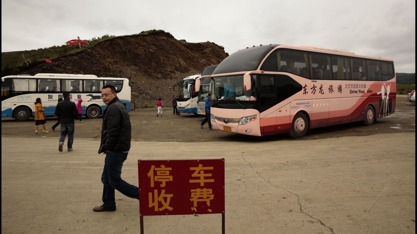 Tour buses deliver visitors to an overlook in Aba for a glimpse of the Tibetan plateau. Unlike the majority Han Chinese, Tibetans face travel restrictions.