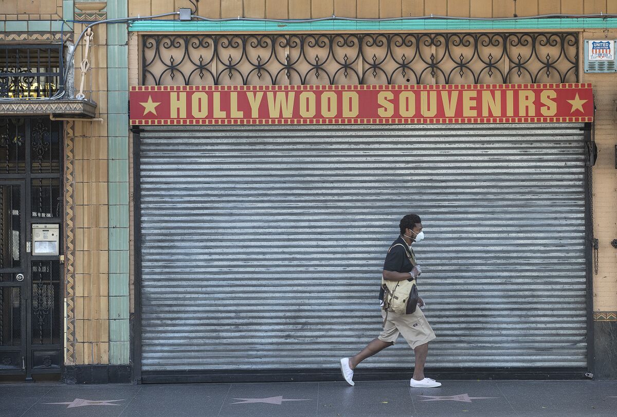 A pedestrian walks past a closed business on Hollywood Boulevard in Hollywood.