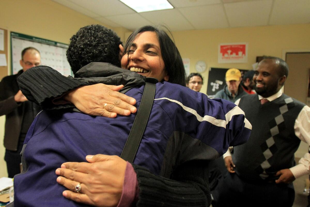 Kshama Sawant hugs campaign worker Carlos Hernandez after they learned she had pulled ahead of opponent Richard Conlin by 41 votes.