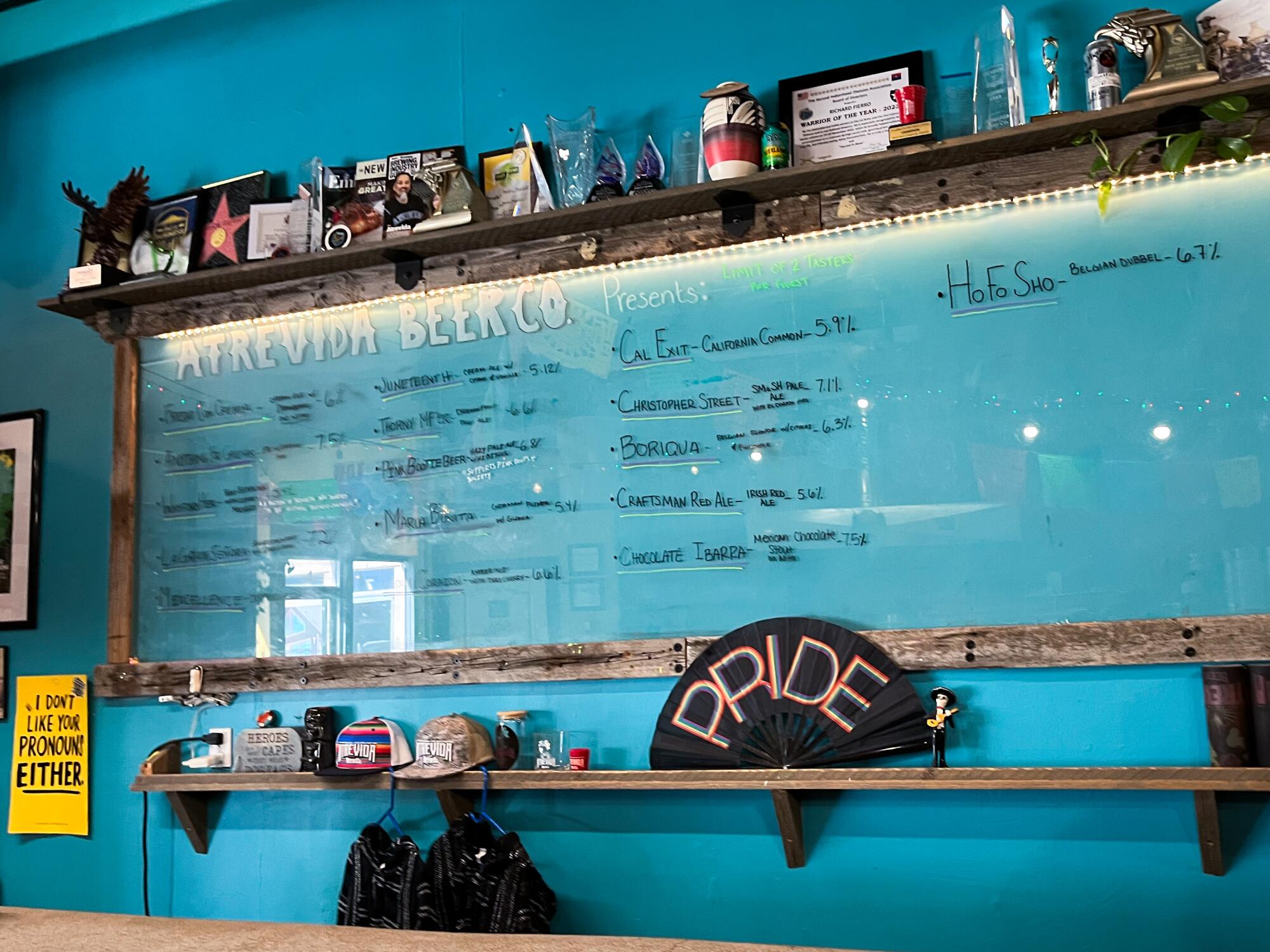 A clear glass board with knickknacks on the ledge above, hangs on a blue wall