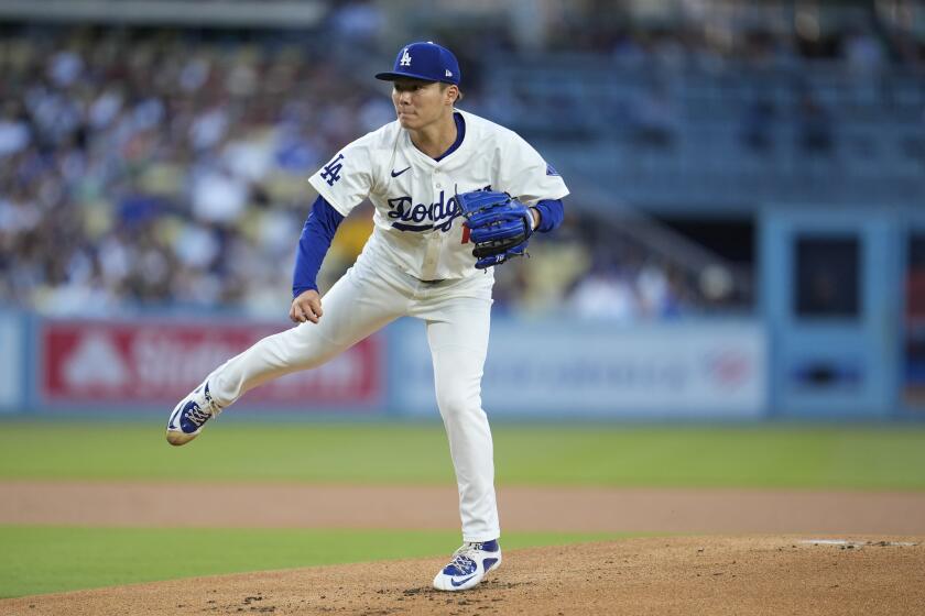 Los Angeles Dodgers starting pitcher Yoshinobu Yamamoto watches a throw to a Miami Marlins batter during the first inning of a baseball game Tuesday, May 7, 2024, in Los Angeles. (AP Photo/Marcio Jose Sanchez)