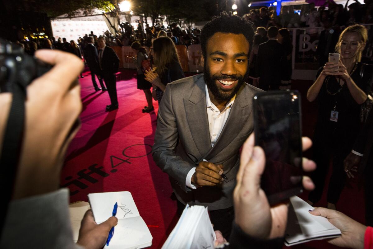 Actor Donald Glover signs autographs and poses for fan photos on the red carpet for the premiere of "The Martian" at the Roy Thompson Hall during the 40th Annual Toronto International Film Festival.