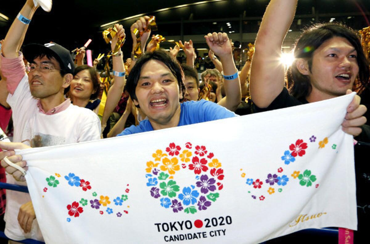 Japanese supporters of the bid for the 2020 Summer Olympic Games celebrate in Tokyo early Sunday morning.