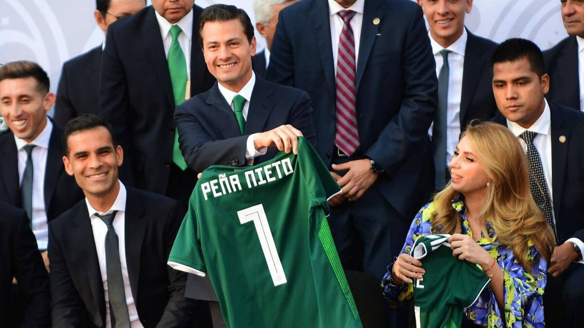 Mexican President Enrique Peña Nieto, center, with Mexican soccer star Rafael Marquez, left, who is accused by the U.S. Treasury Department of aiding a drug kingpin.