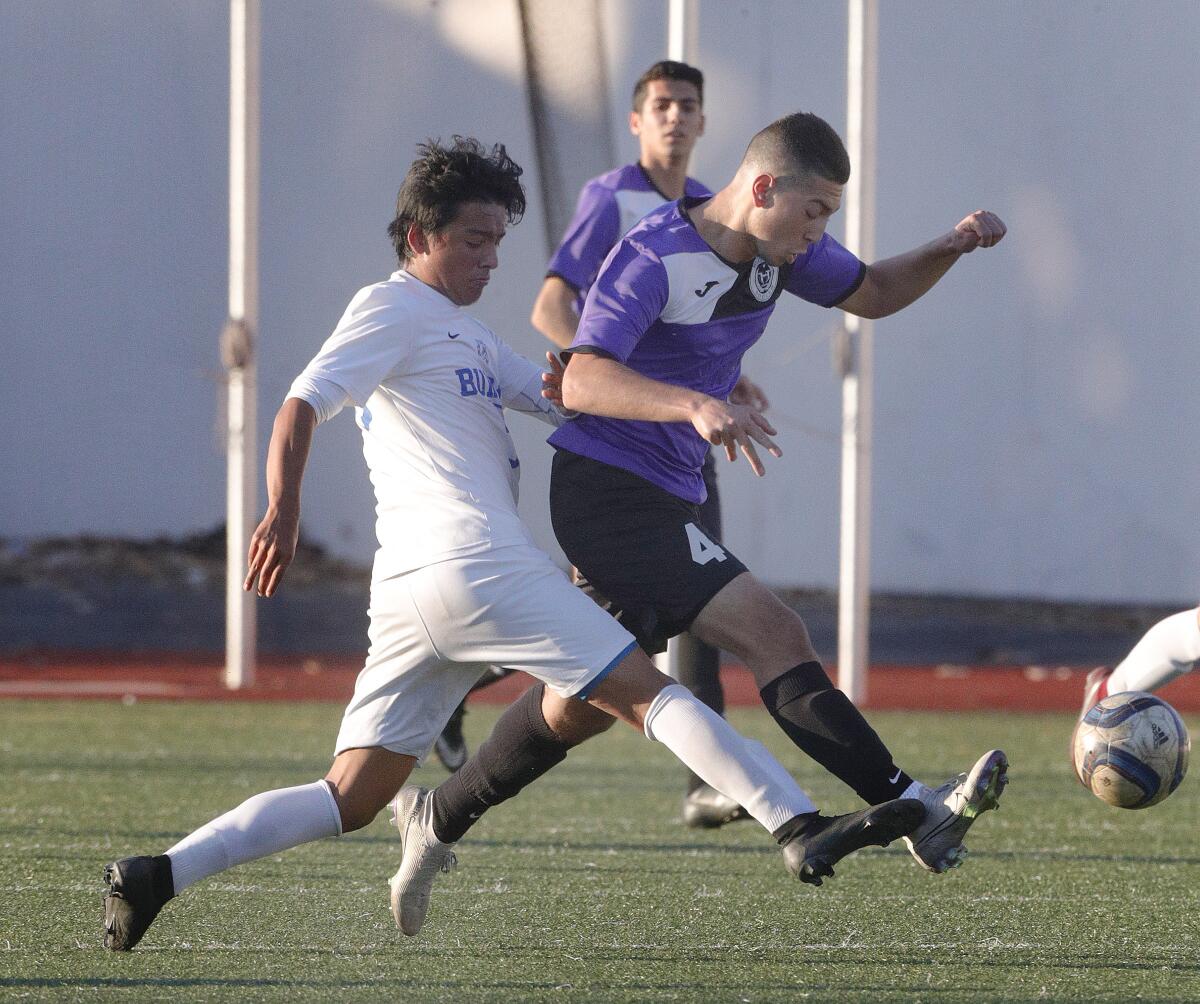 Hoover’s Kayk Torosyan battles Burbank’s Jorge Ortega for the ball in a Pacific League boys' soccer game at Hoover High School on Friday, January 3, 2020.