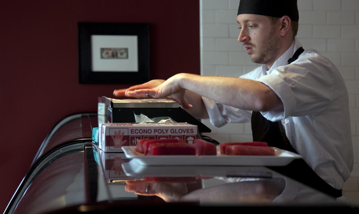 Nathan McCall prepares to weigh tuna steaks for a customer at his McCall's Meat & Fish Co. on Hillhurst in Los Feliz