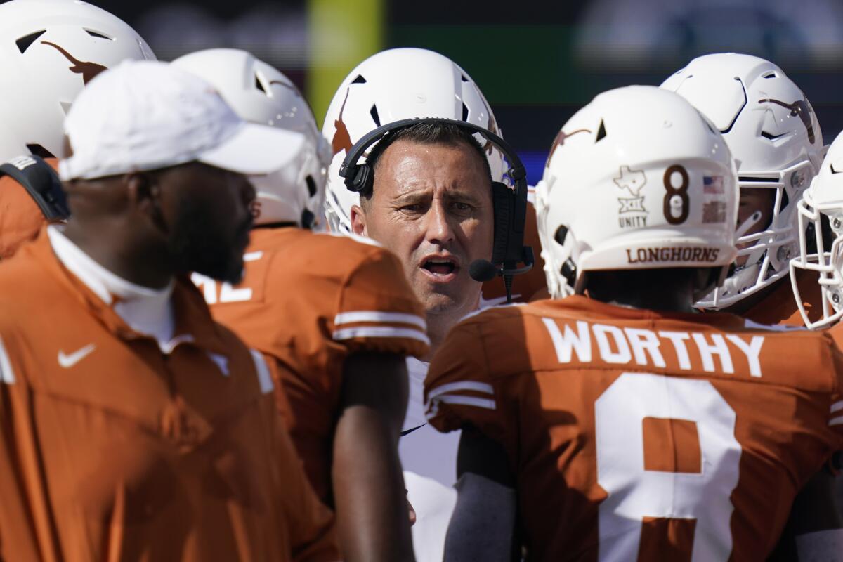 Texas coach Steve Sarkisian, center, talks with players during a timeout against Louisiana Lafayette on Sept. 4, 2021.