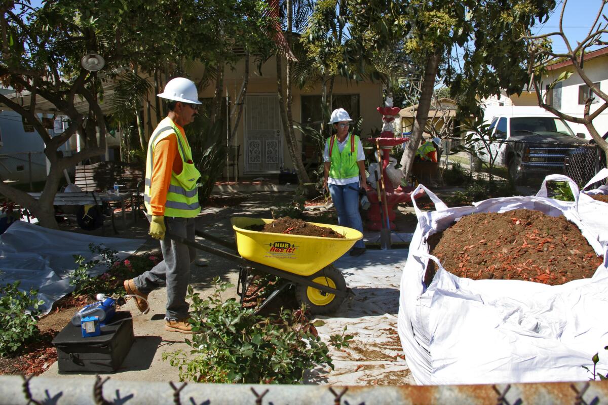 Workers remove topsoil in March from homes in Boyle Heights that may have been contaminated by lead that possibly came from Exide Technologies, a battery recycling plant in Vernon.