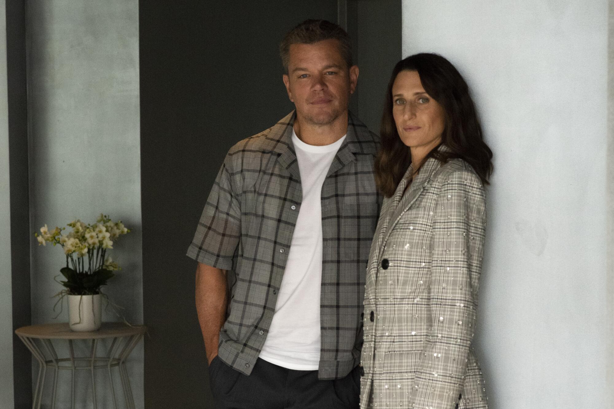 Matt Damon and Camille Cottin lean on a wall