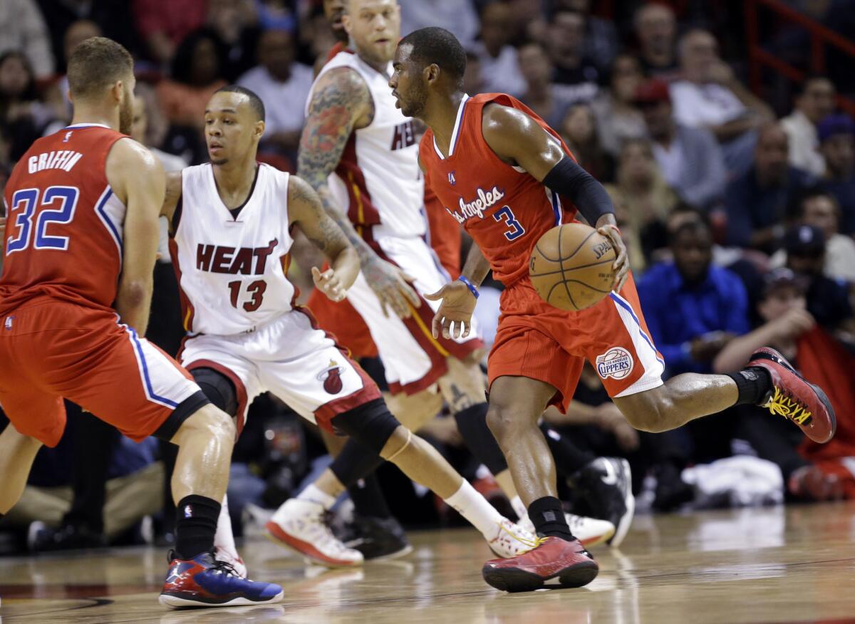 Chris Paul drives up the court as Miami rookie guard Shabazz Napier (13) defends during the first half of a game on Thursday.