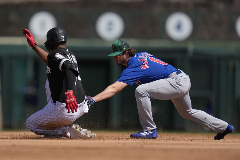 Chicago White Sox's Eloy Jimenez (74) reaches second on a double ahead of a tag from Chicago Cubs second baseman Zach McKinstry (6) during the second inning of a spring training baseball game in Glendale, Ariz., Friday, March 17, 2023. (AP Photo/Ashley Landis)