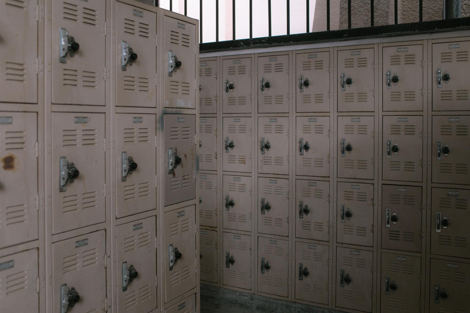 Rows of pale, dimly lit lockers with combination locks.