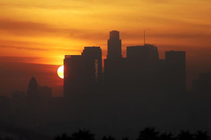 LOS ANGELES, CALIF. DEC. 14, 2016. The sun sets behind the downtown Los Angeles skyline as the marine layer envelops the surrounding basin on Wednesday, Dec. 14, 2016. Heavy rain is expected to fall on Southern California on Thursday and Friday. (Luis Sinco/Los Angeles Times)