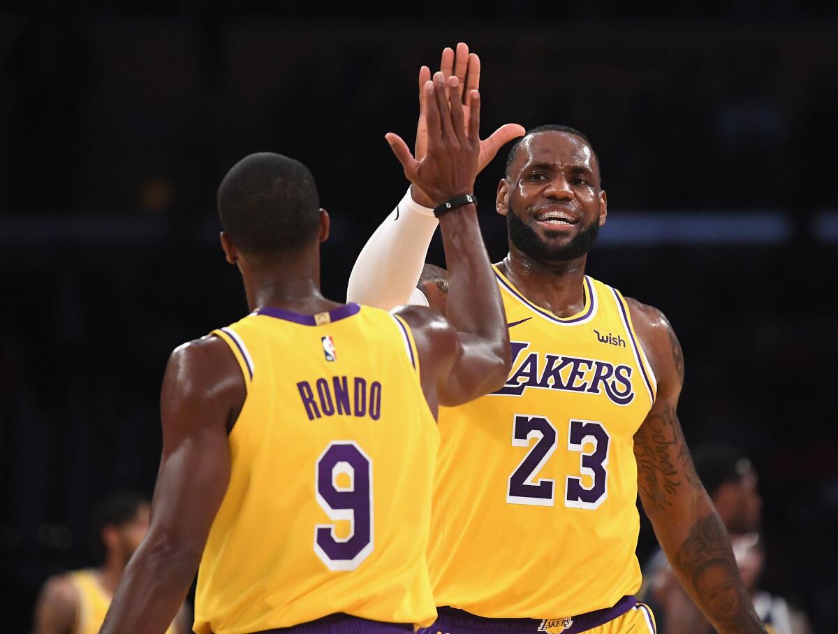 Lakers point guard Rajon Rondo and forward LeBron James celebrate during a game last season.