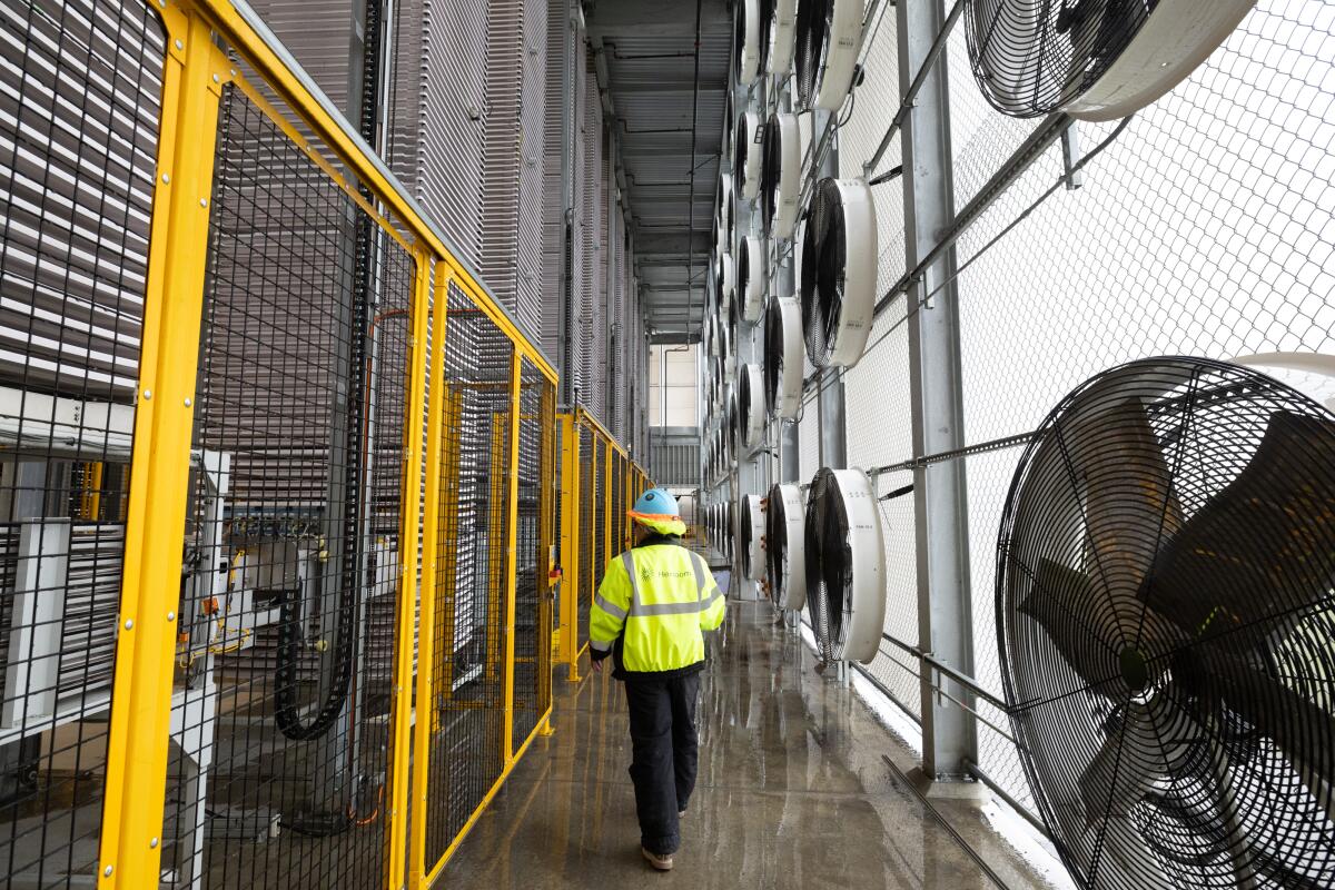 A technician walks inside a commercial carbon capture facility
