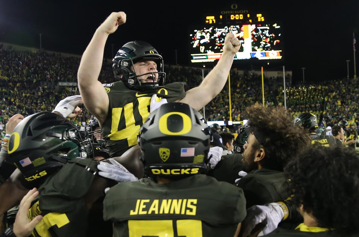 Oregon's Camden Lewis celebrates his game-winning 26-yard field goal with teammates Saturday night.