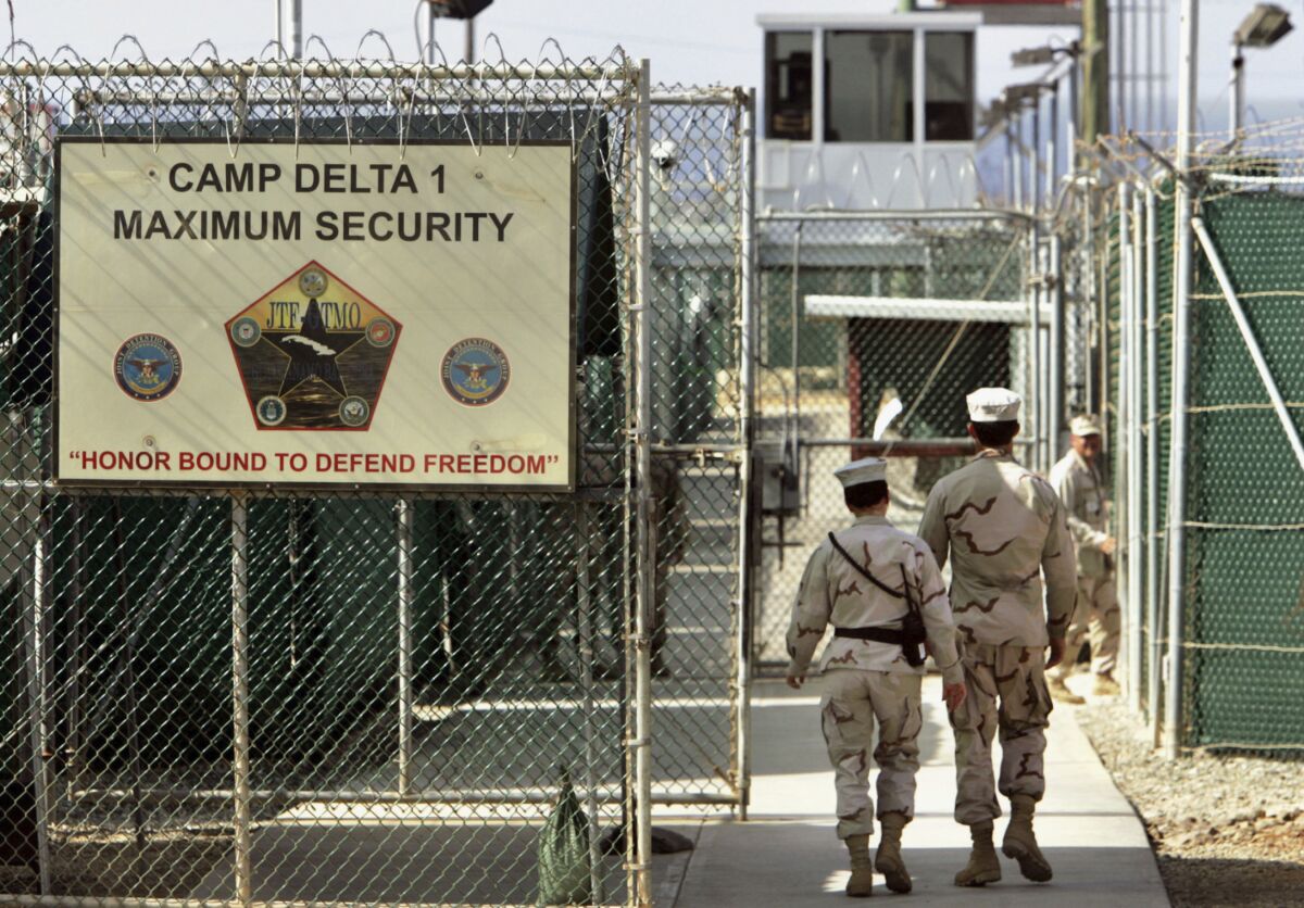 FILE - In this June 27, 2006, file photo, reviewed by a U.S. Department of Defense official, U.S. military guards walk within Camp Delta military-run prison, at the Guantanamo Bay U.S. Naval Base, Cuba. A federal judge has turned back an effort to delay an independent medical review for Saudi citizen Mohammed al-Qahtani, held at the Guantanamo Bay detention center who was so badly mistreated in American custody that he cannot be put on trial. (AP Photo/Brennan Linsley, File)