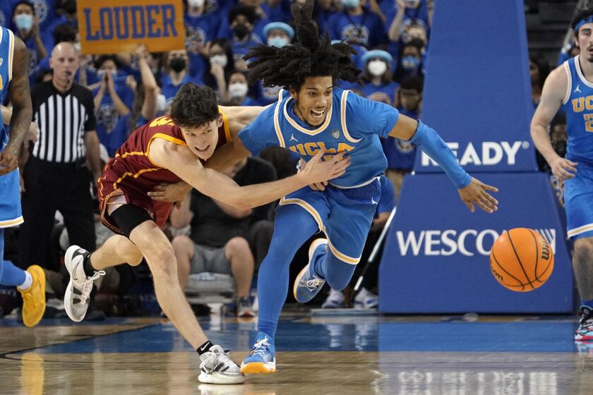 UCLA guard Tyger Campbell, right, and Southern California guard Drew Peterson go after a loose ball.