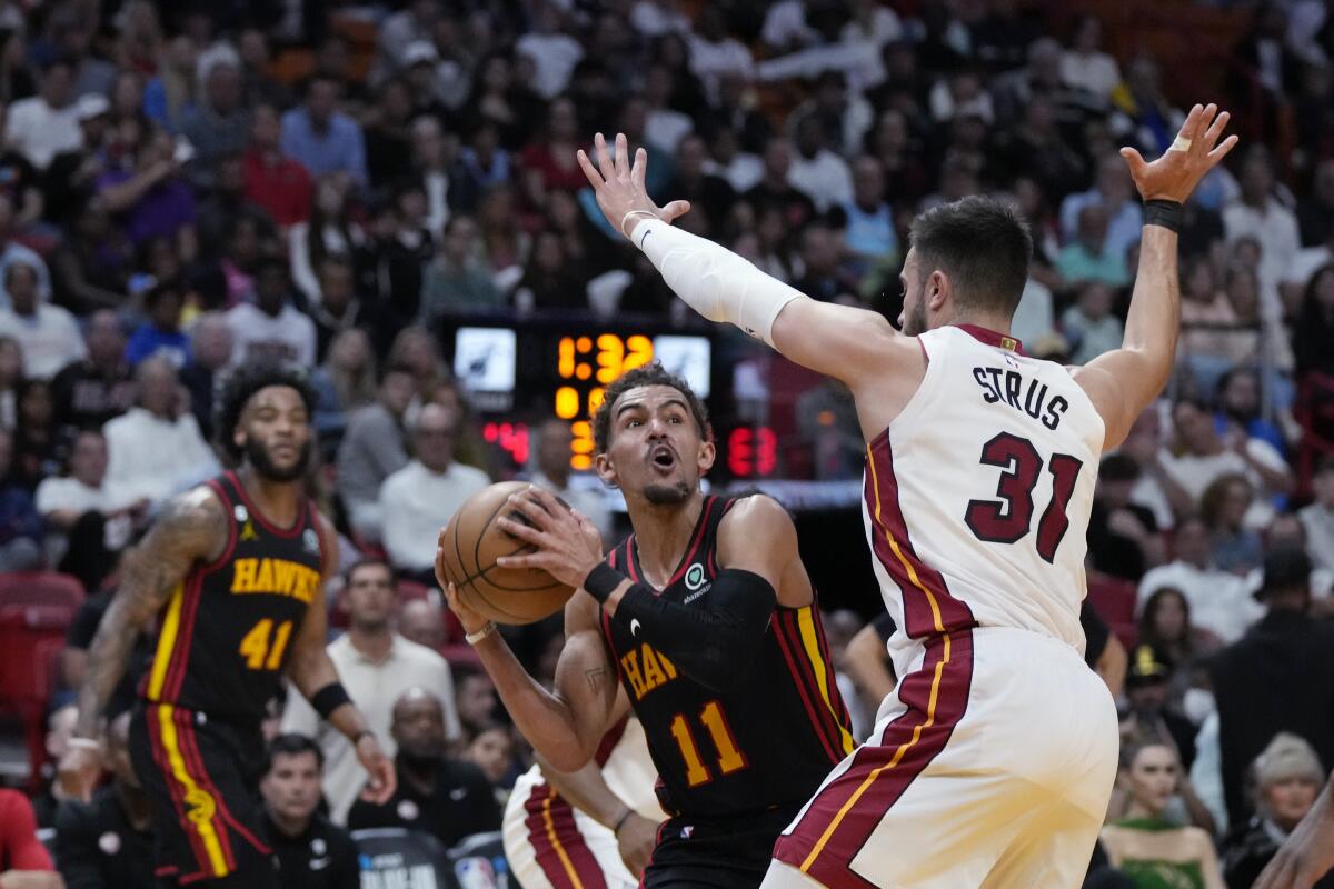 Atlanta Hawks guard Trae Young looks for a shot as Miami Heat guard Max Strus defends.