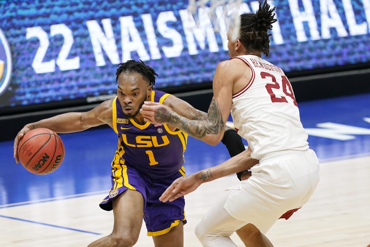 LSU's Ja'Vonte Smart (1) drives against Arkansas' Ethan Henderson (24) in the first half of an NCAA college basketball game in the Southeastern Conference Tournament Saturday, March 13, 2021, in Nashville, Tenn. (AP Photo/Mark Humphrey)