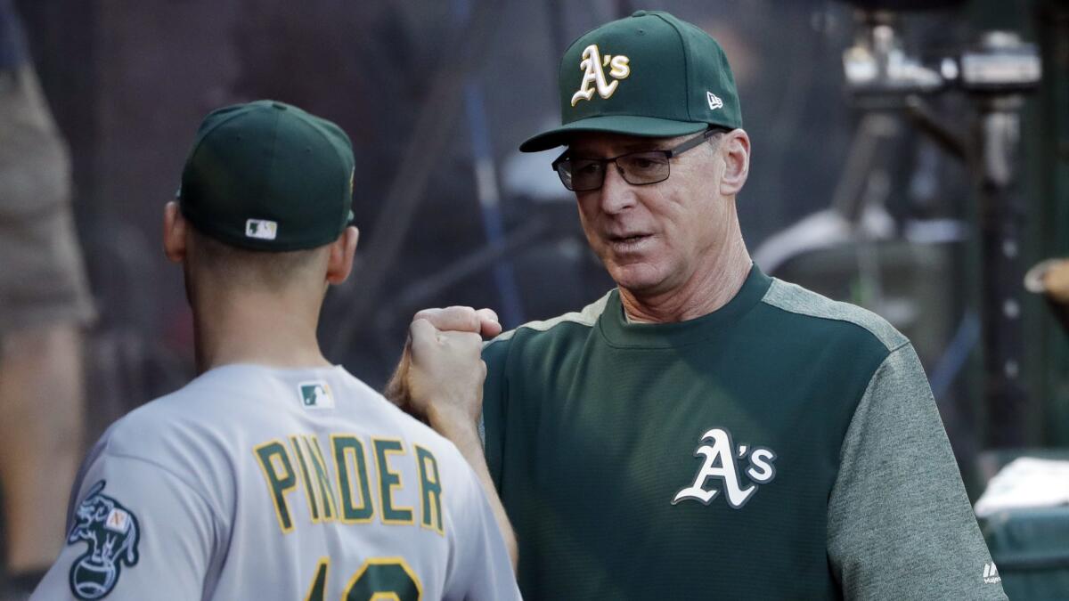 Oakland Athletics manager Bob Melvin, right, gives a fist-bump to Chad Pinder before the team's game against the Angels.