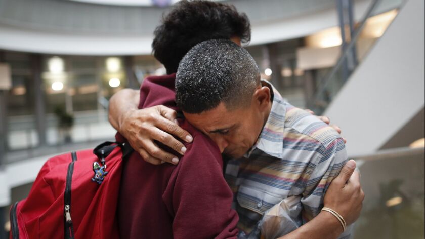 Edvin Cazun, right, and son Samuel of Guatemala reunite in Cincinnati on July 23, about a month after they were separated when they crossed the Rio Grande into the United States.