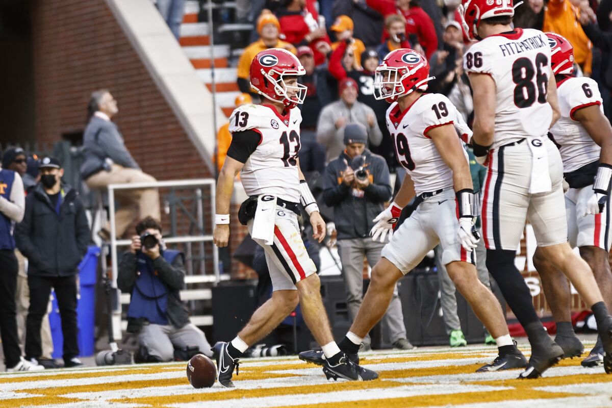 Georgia quarterback Stetson Bennett (13) celebrates after scoring a touchdown with tight end Brock Bowers (19) during the first half of an NCAA college football game against Tennessee Saturday, Nov. 13, 2021, in Knoxville, Tenn. (AP Photo/Wade Payne)