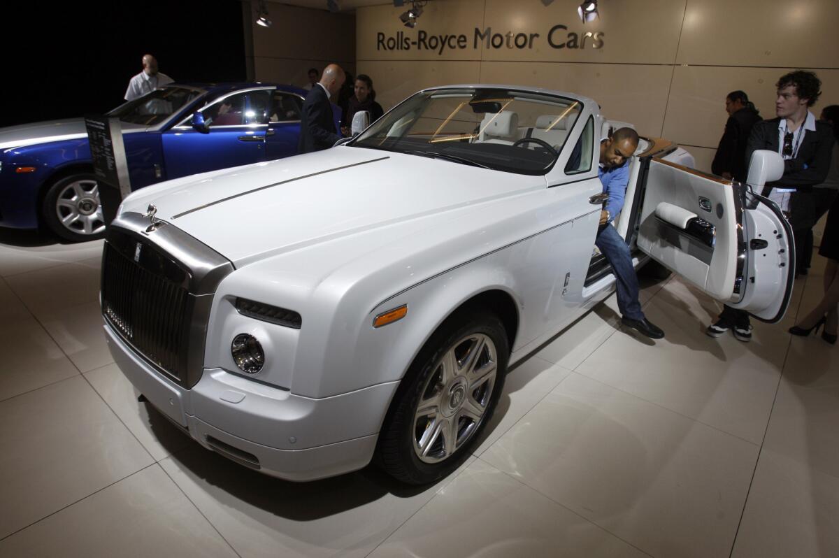 Media members view the Rolls-Royce Phantom Drophead Coupe at the 2011 L.A. Auto Show. Rolls confirmed Tuesday it would add a fourth "high-bodied" model to the lineup in the coming years.