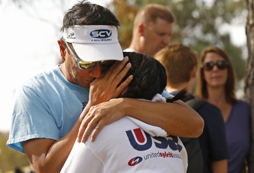 Emerson Cabigting hugs his daughter, Ella, a 10th-grader at Saugus High School, as they are reunited at a nearby park.