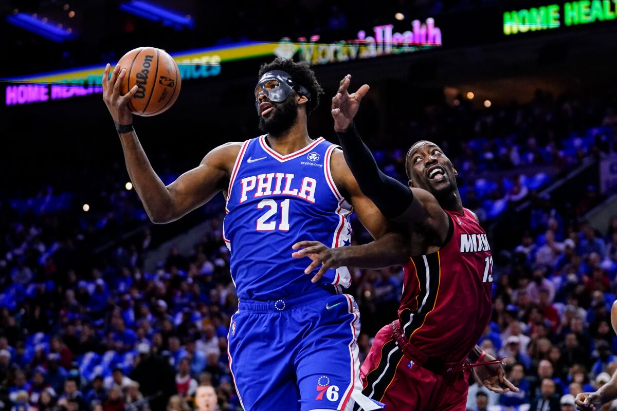 The 76ers' Joel Embiid, left, and the Heat's Bam Adebayo battle for the ball Friday night during Game 3 on May 6, 2022.