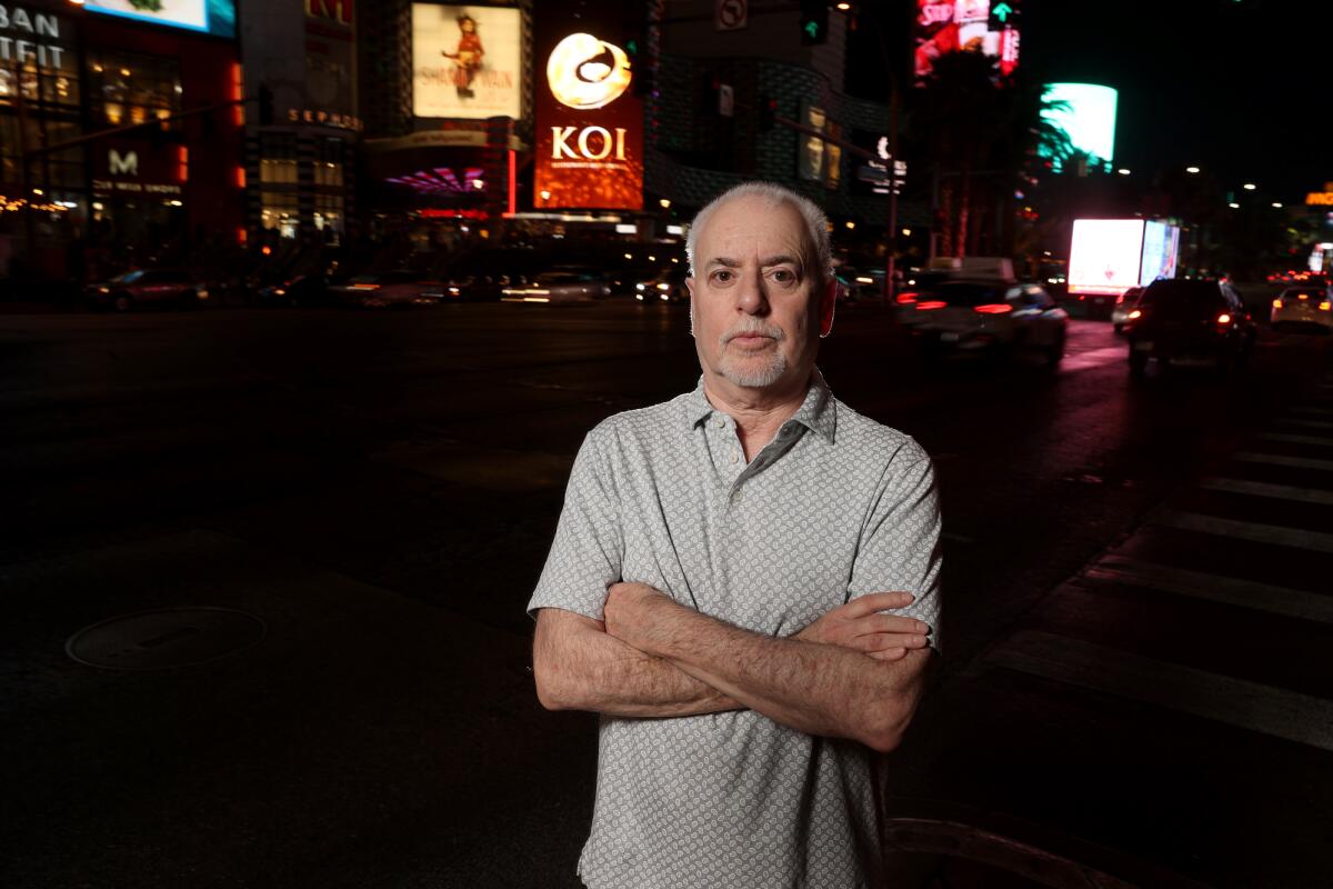 A man standing on the Strip in Las Vegas with his arms crossed.