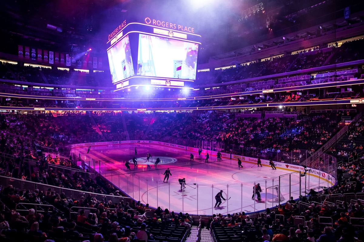 The Edmonton Oilers and Winnipeg Jets warm up before a game in a crowd-filled arena