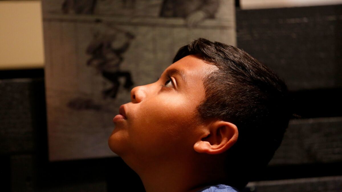 Fernando Quiroz, 11, a student at Southeast Middle School, takes in an exhibit at La Plaza de Cultura y Artes