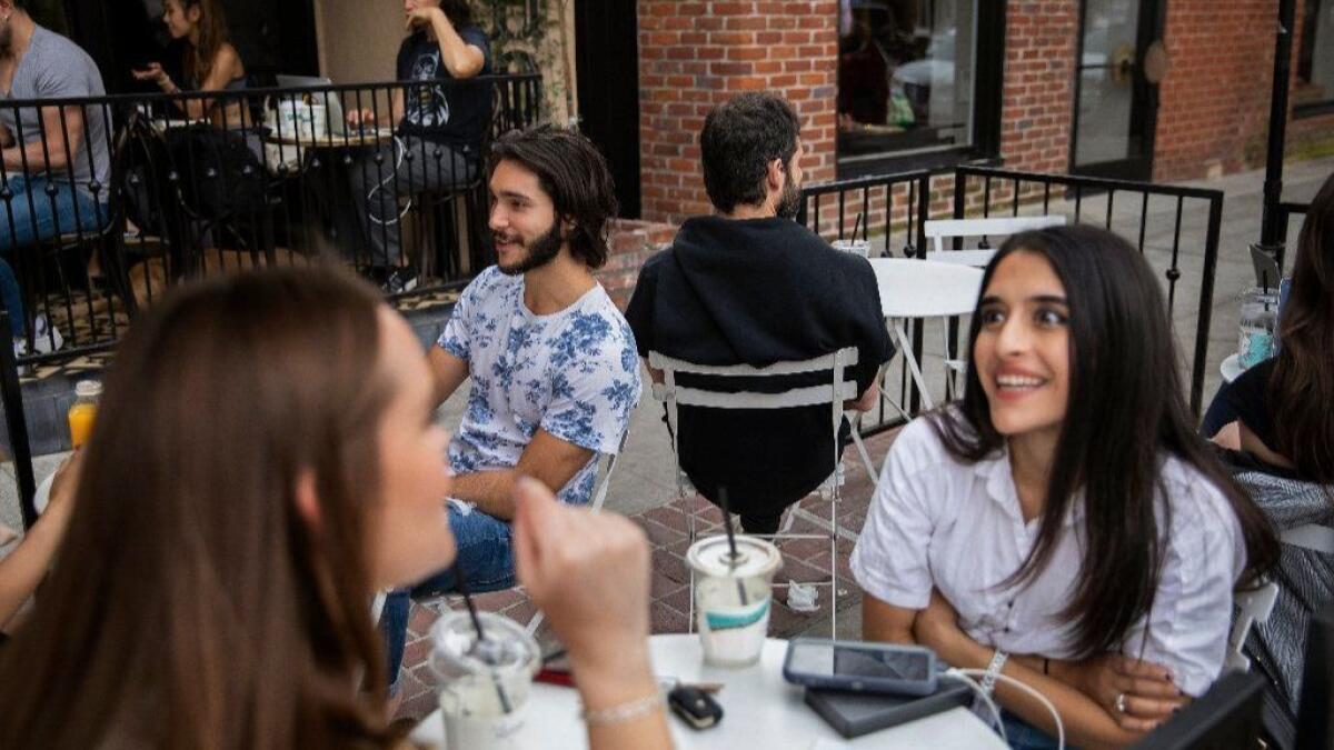 Jesse Margolis, with back to camera, sits among customers at Alfred Coffee Melrose Place in Los Angeles. Will their conversations end up on Overheard LA, the popular Instagram account he founded?