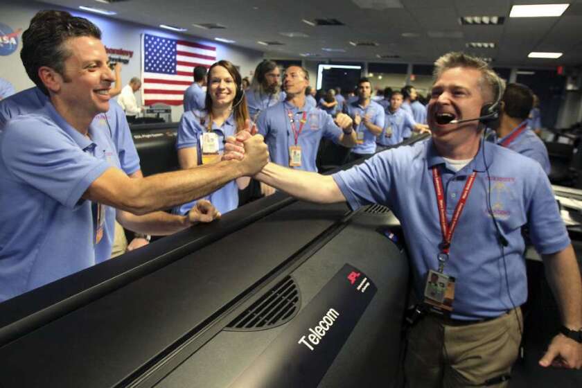 Flight director Keith Comeaux, right, and Martin Greco are jubilant in JPL's mission control room, which erupted in cheers after receiving word of Curiosity's successful landing on Mars.