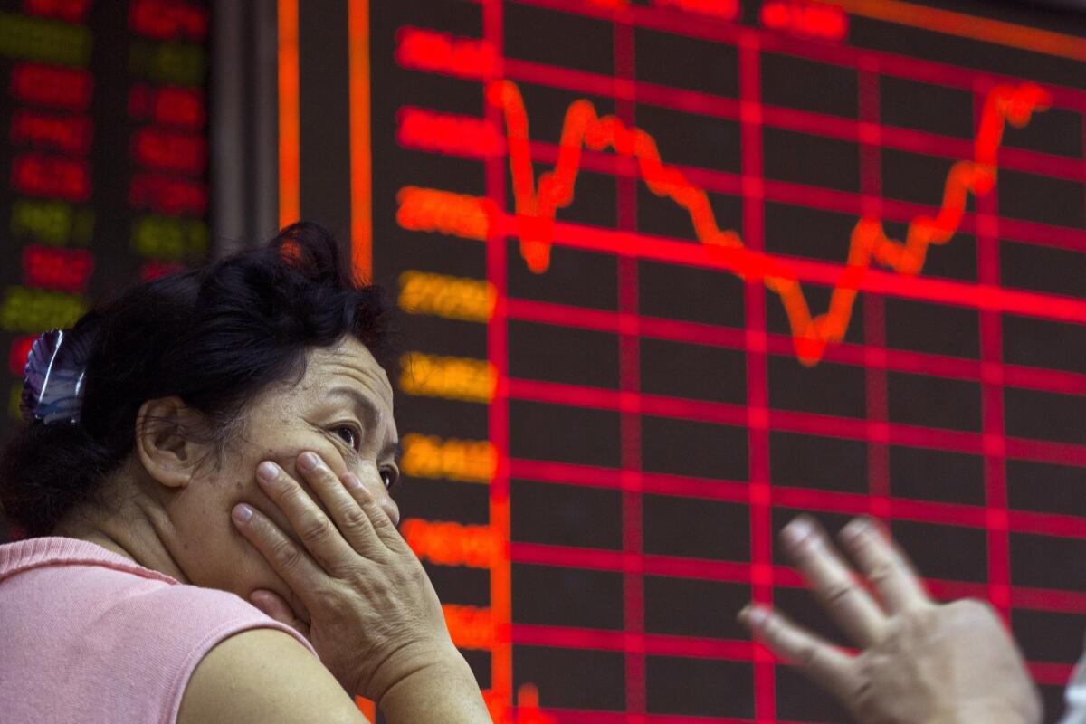 A Chinese investor monitors stock prices at a brokerage in Beijing on Aug. 26. Asian stocks were mixed Wednesday and Shanghai's index fell despite Beijing's decision to cut a key interest rate.